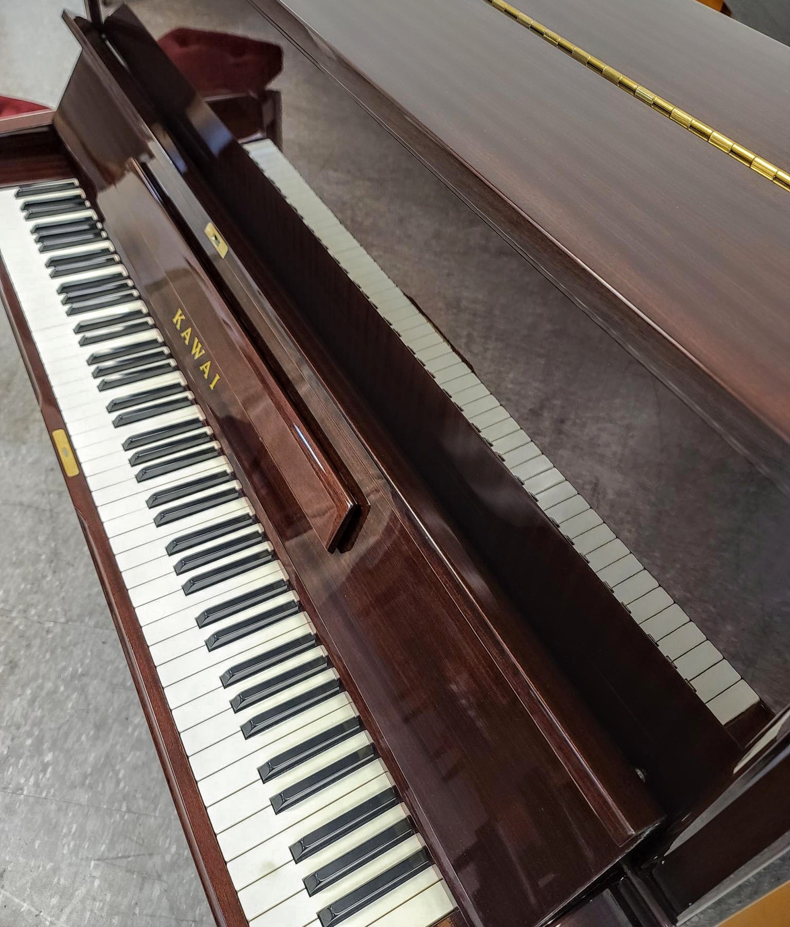 Beautiful Kawai professional upright piano profiled front view.  Has beautifully grained custom wood case.